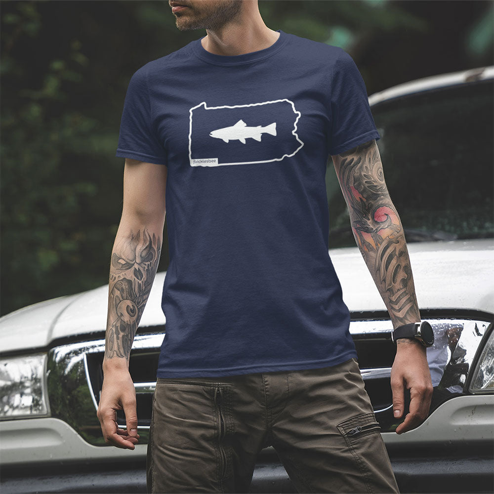 Keystone State Line Trout Fishing T-shirt on tattooed man in front of his truck in the woods