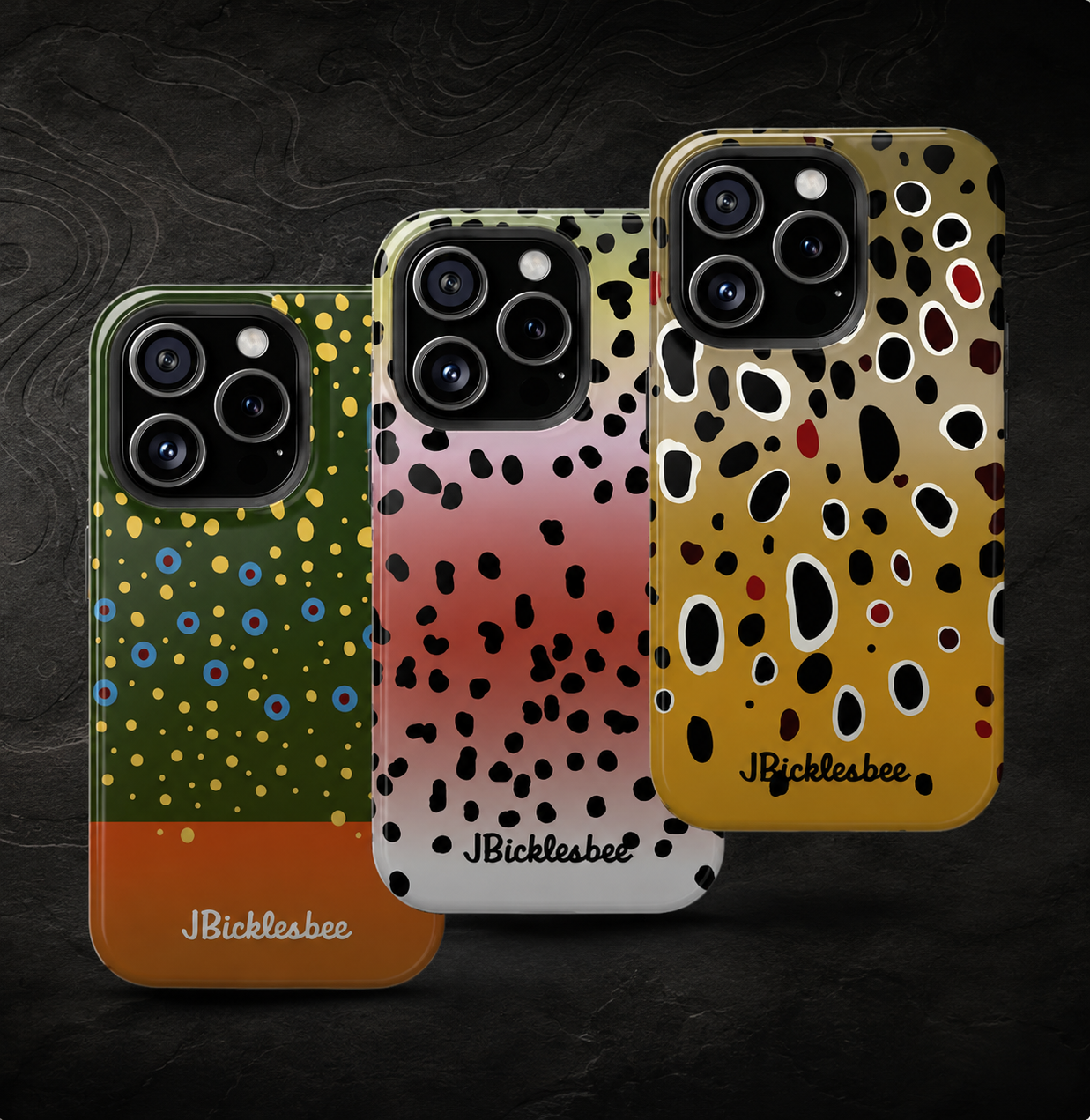 Three JBicklesbee phone cases with colorful fish-inspired patterns displayed against a dark textured background