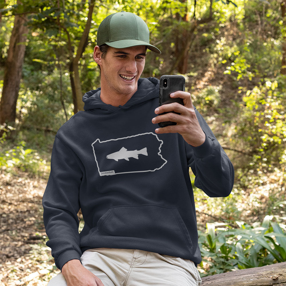 man wearing the Keystone State Trout Fishing Hoodie in the woods