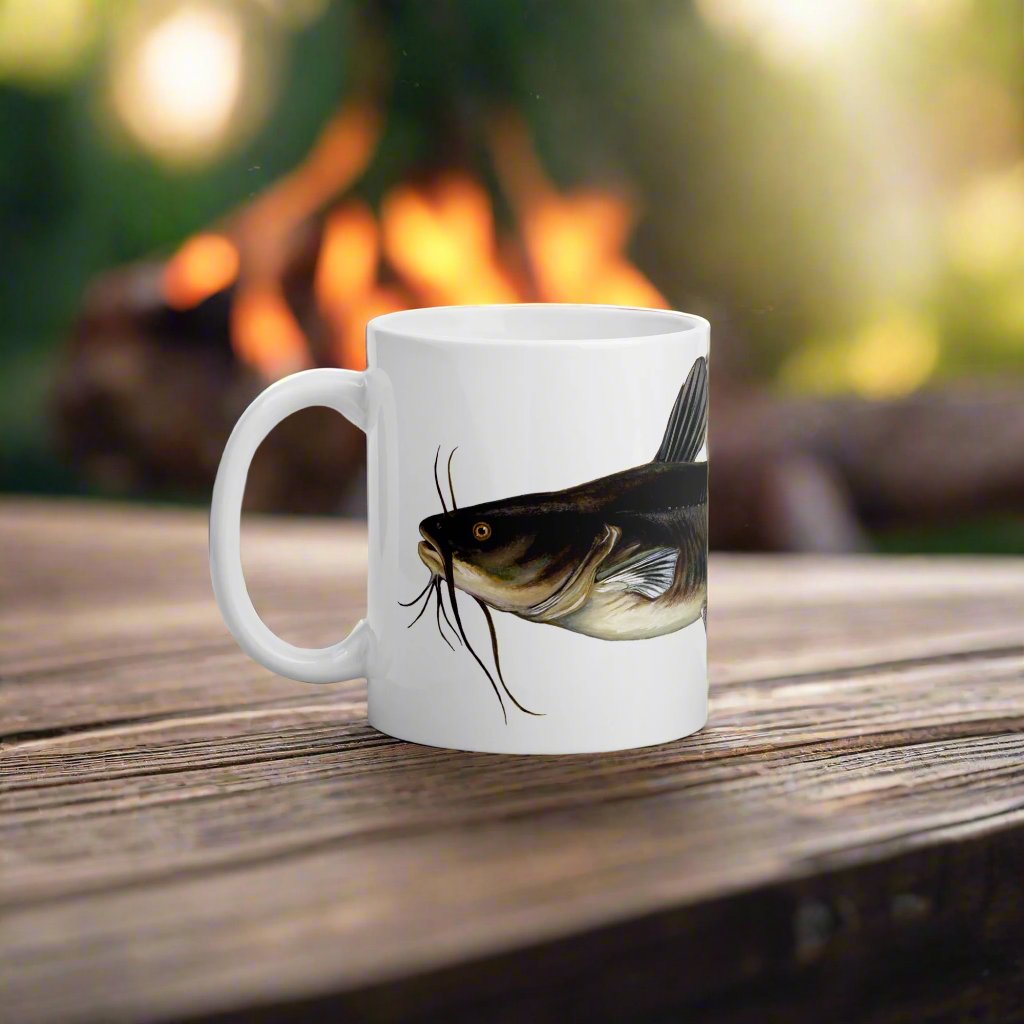 catfish coffee mug sitting on a table camp site in the background