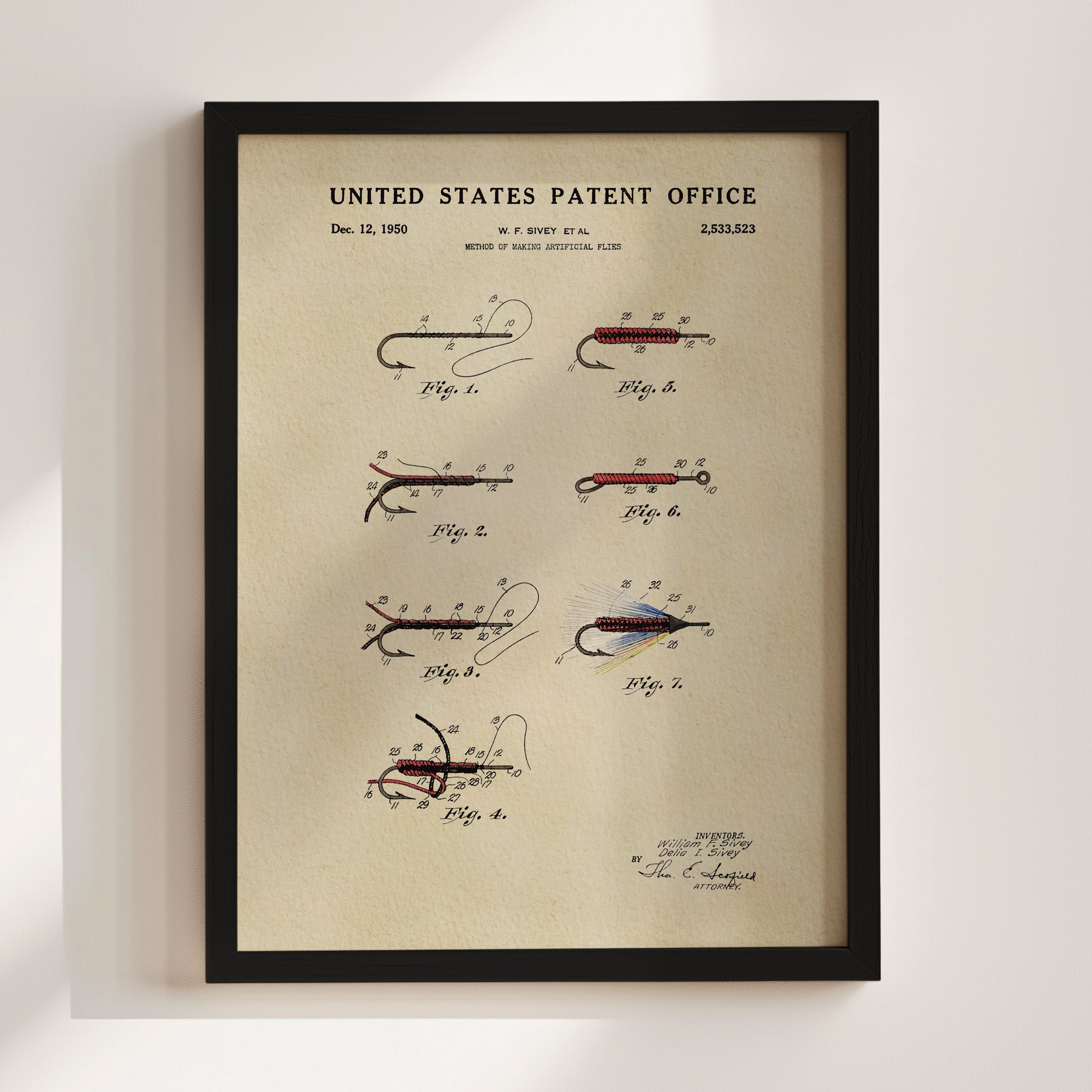 Framed fly fishing flies patent print displayed as fishing wall art on a light wall.