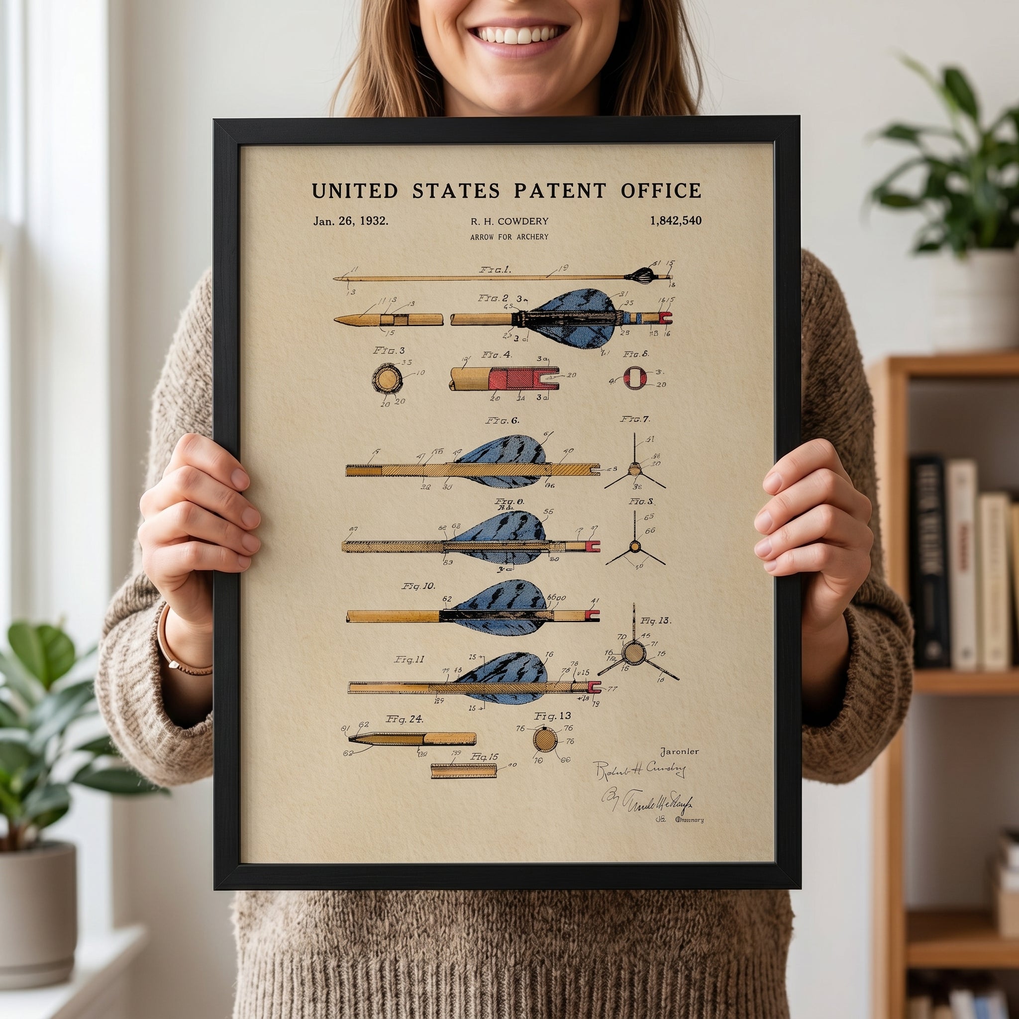 Woman holding a framed Archery Arrow patent print with vintage watercolor artwork