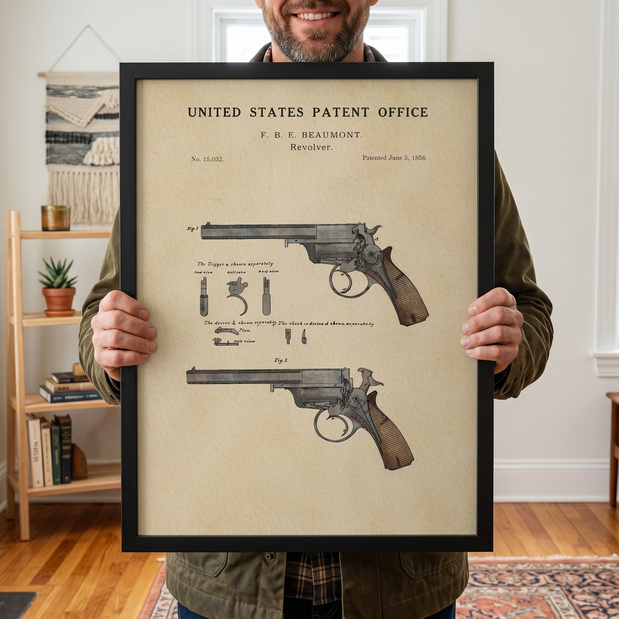 Man holding a framed Beaumont Revolver patent print with vintage watercolor artwork