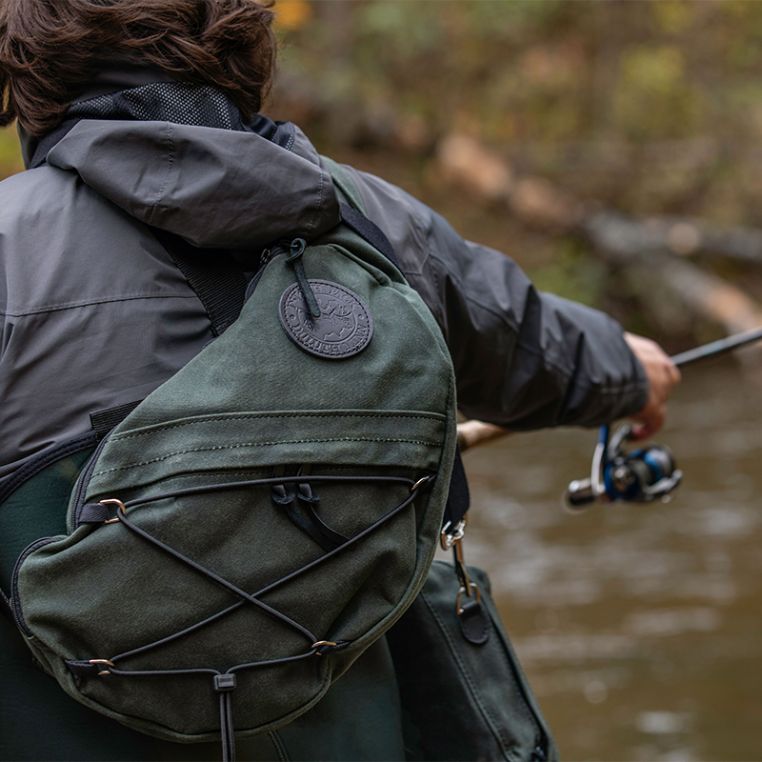 Angler wearing the Duluth Pack 16L Canvas Sling Pack while spin fishing