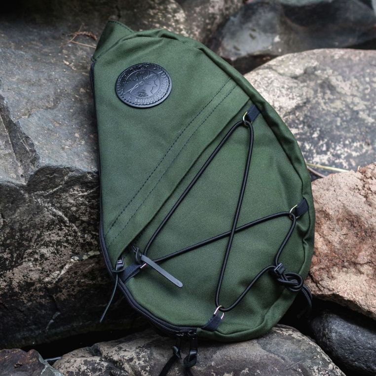 Duluth Pack 16L Canvas Sling Pack resting on a rock outdoors