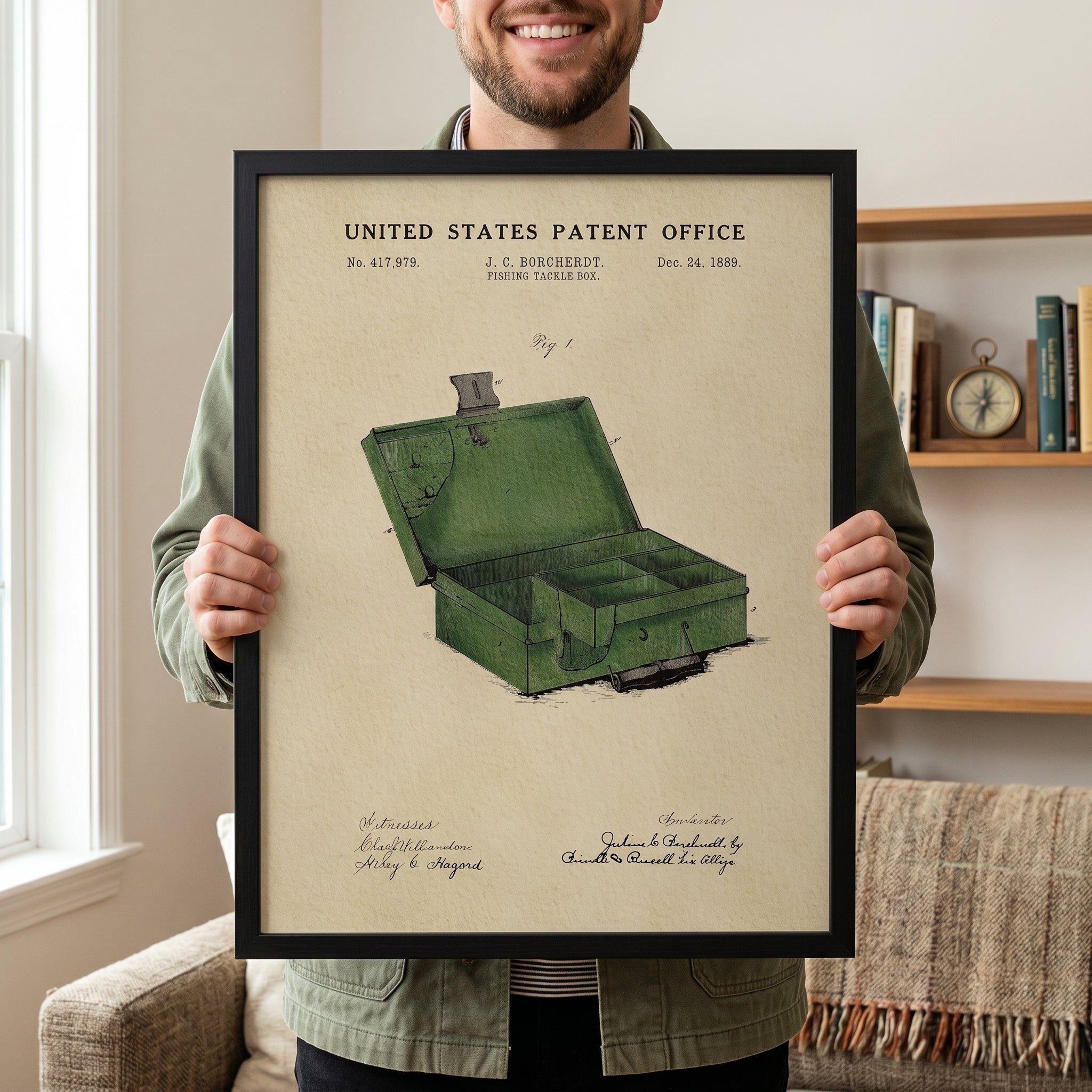 Person holding a large framed 1889 Fishing Tackle Box patent print to show scale.