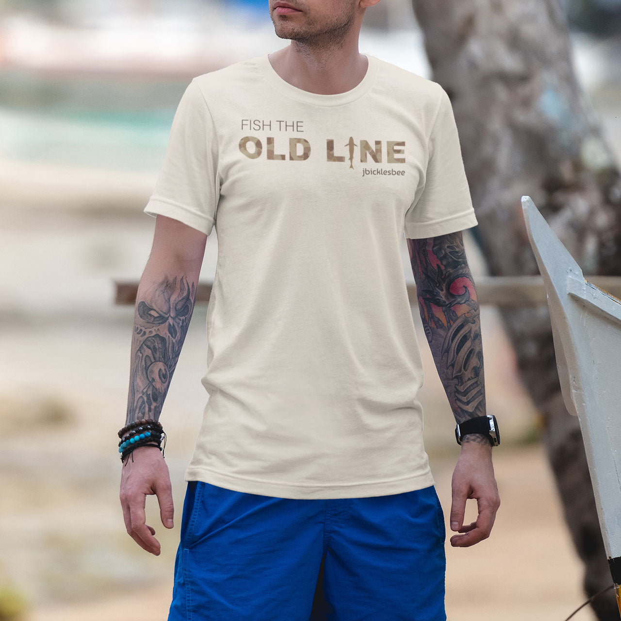 man on the beach wearing fish the old line t-shirt heather dust