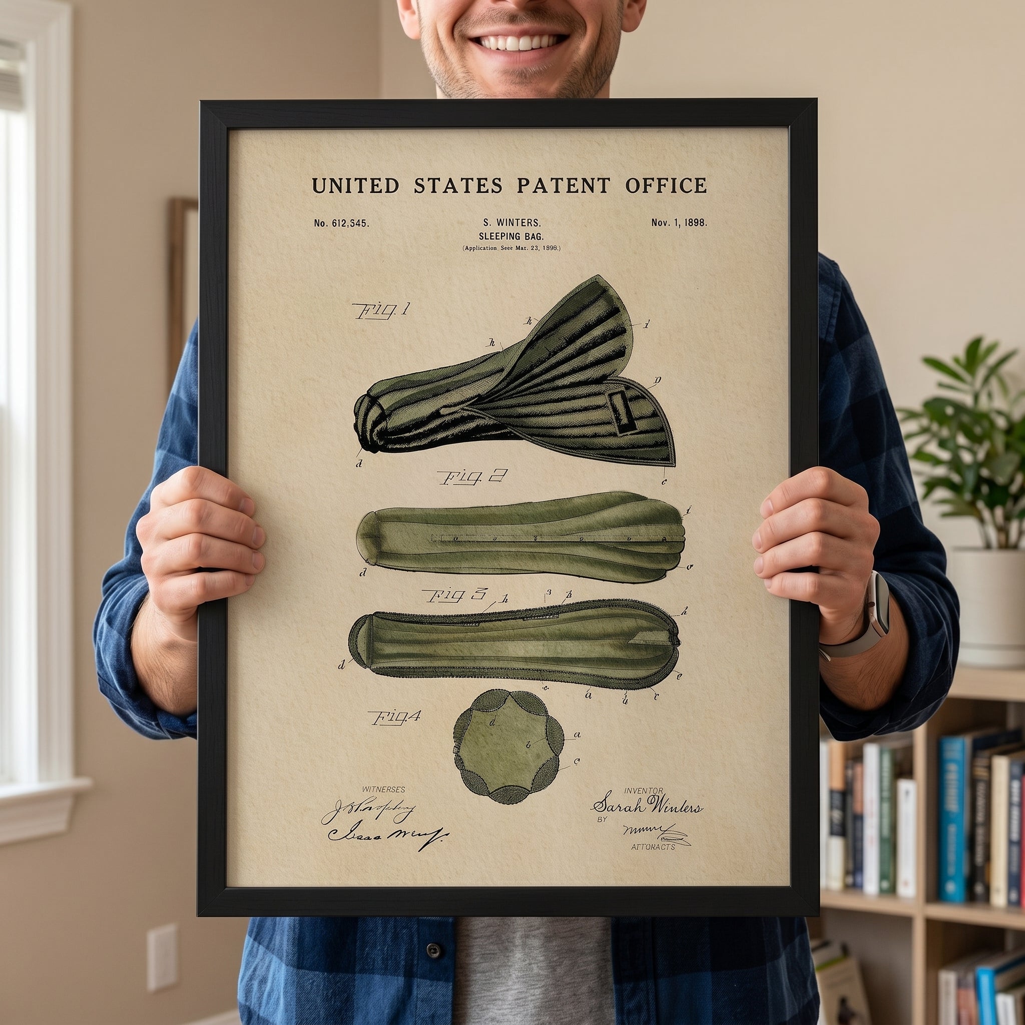 Person holding a large framed 1898 Sarah Winters Sleeping Bag patent print to show scale.