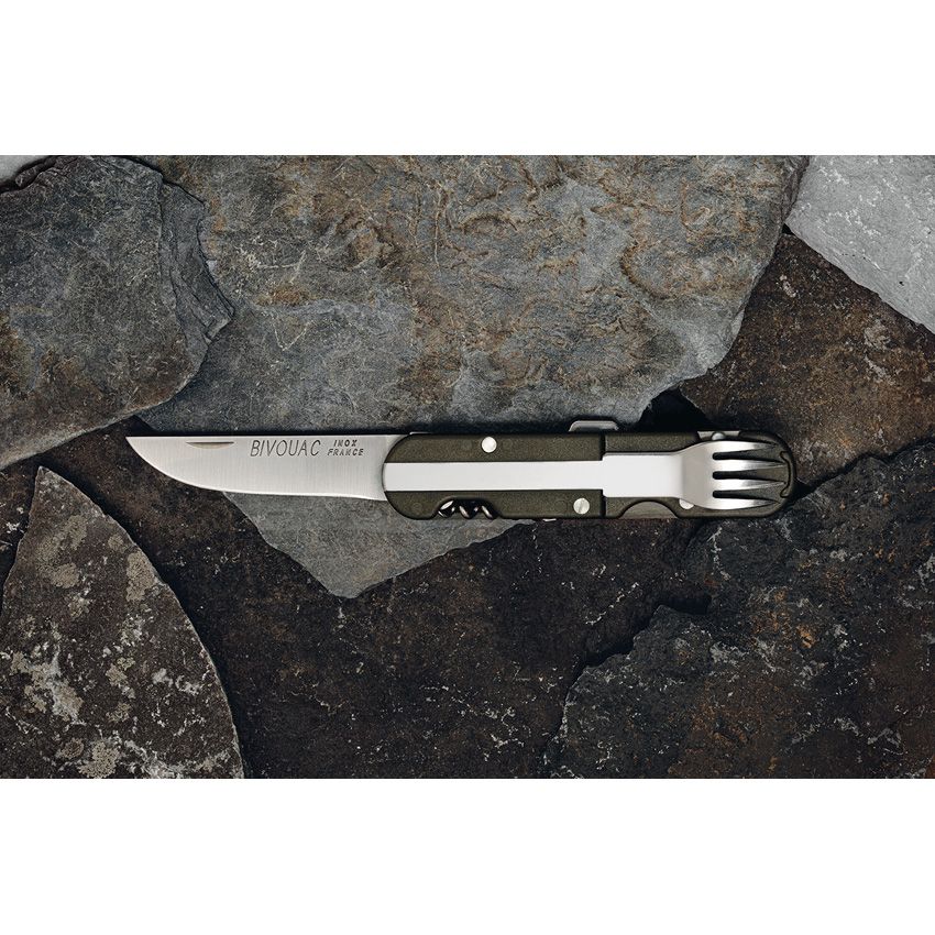 Open TB Bivouac French Army Camp Knife displayed on rocks outdoors