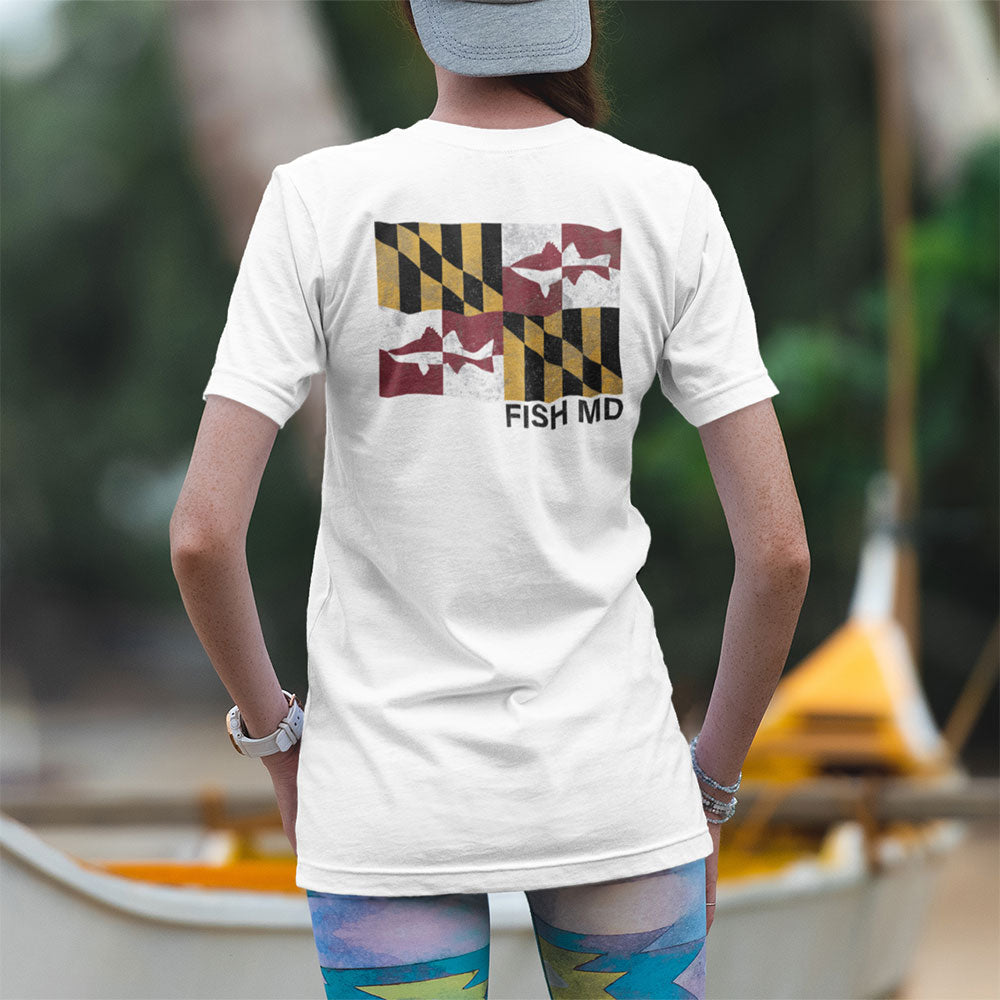 woman wearing MD flag rockfish tshirt on a beach with canoe