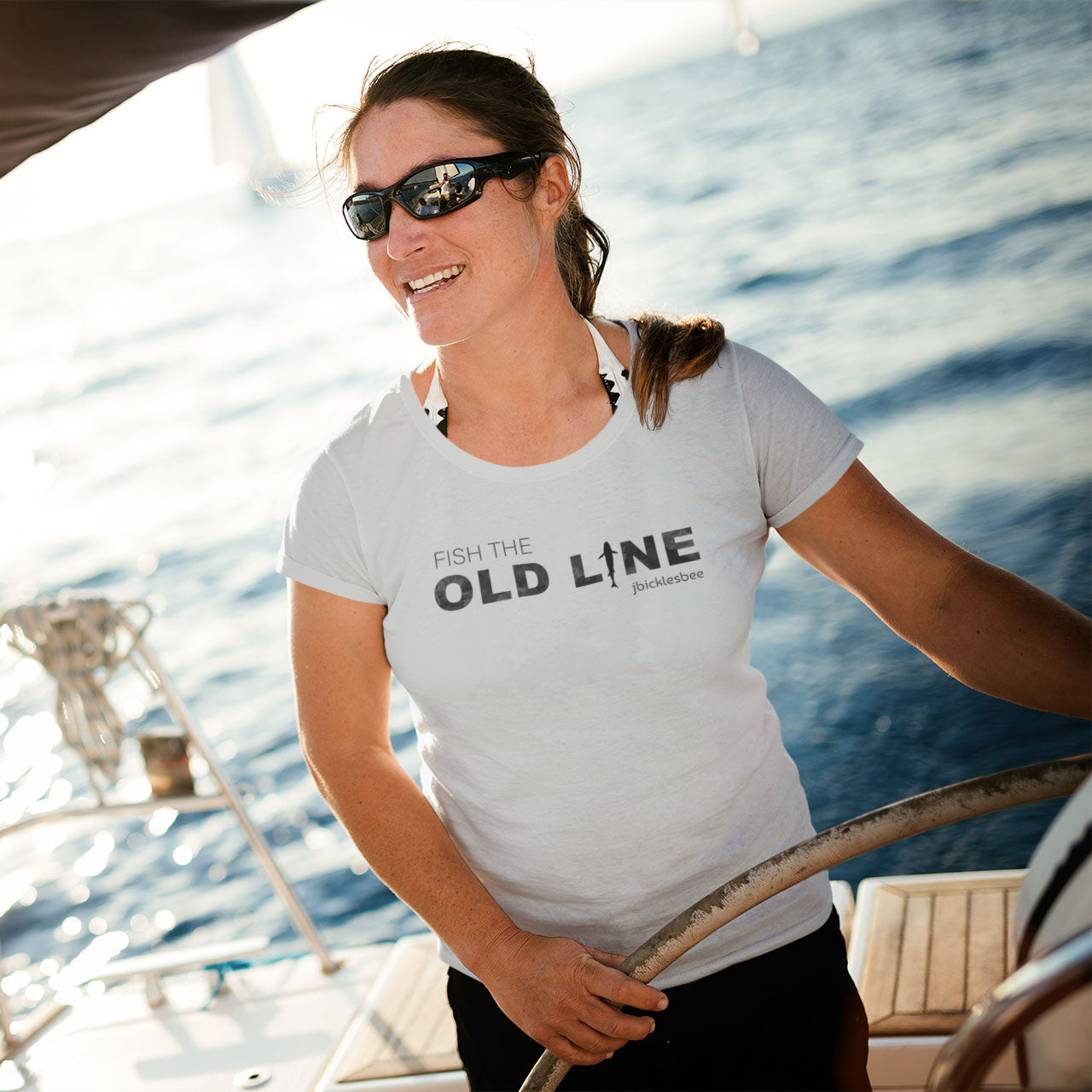 woman on a sailboat wearing fish the old line athletic heather
