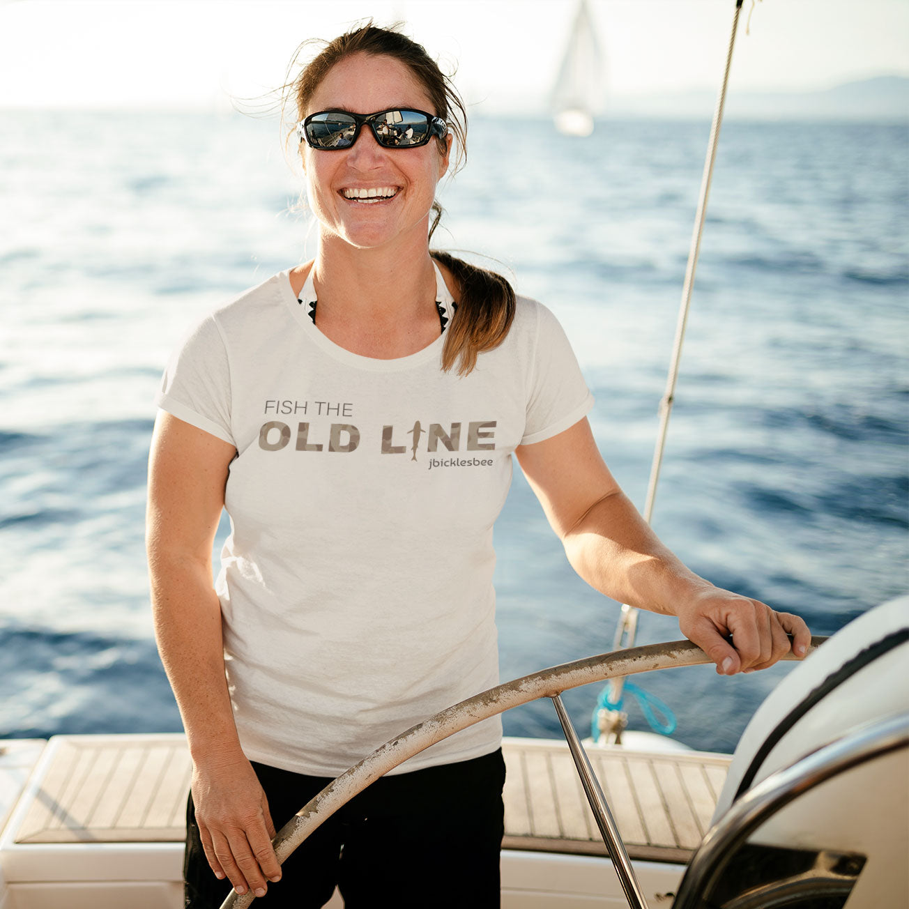 woman on sailboat wearing Old Line heather dust t-shirt